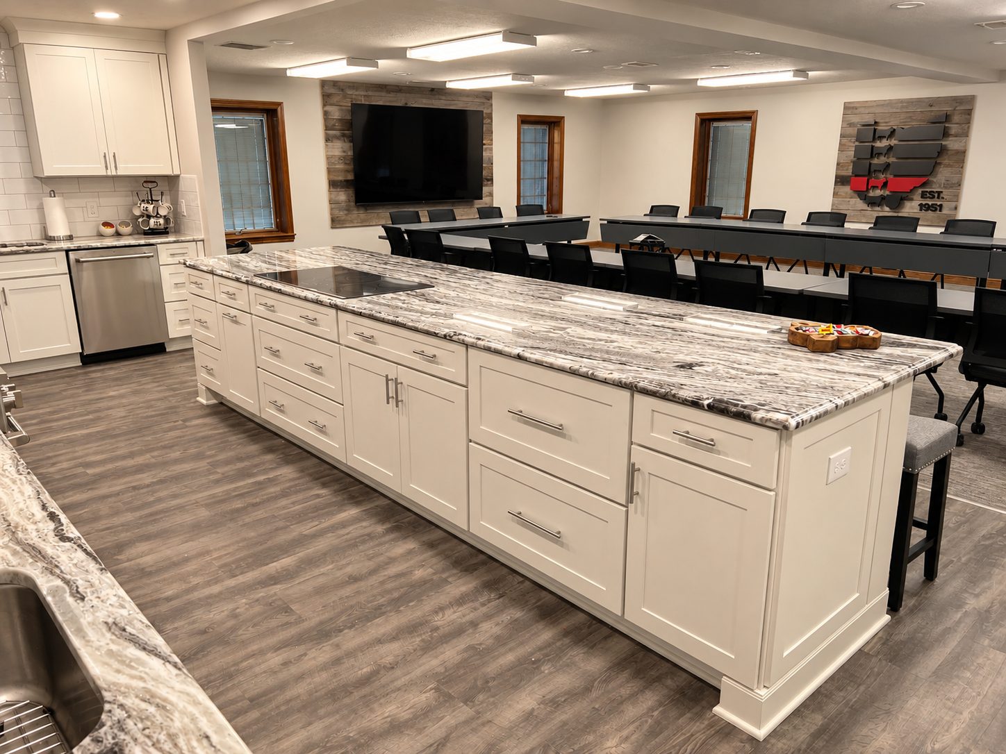 Long white kitchen island with quartz waterfall countertop and bar seating