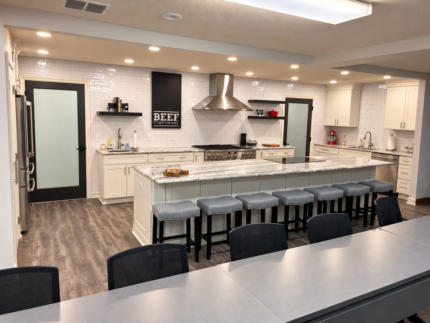 Open kitchen and gathering space with island seating and wall-mounted TV