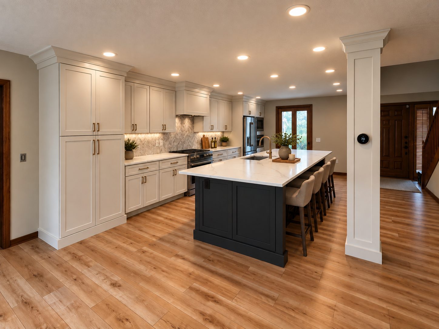 Open kitchen with navy island, white cabinetry, and view into the entry
